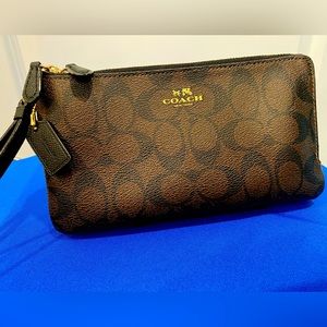 Leather Coach wristlet in Brown Signature C design.